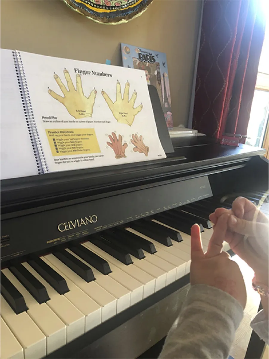 Alumno aprendiendo la numeración de los dedos en el piano
